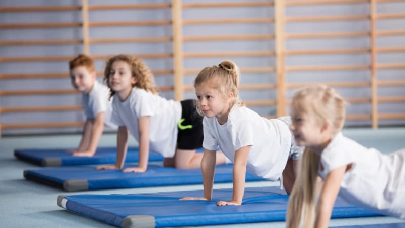 Dzieci wykonujące ćwiczenia na materacach